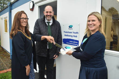 Cllr Petra Pemberton (Thatcham Town Mayor), Lee Dillon MP, and Response's Associate Director of Marketing, Fundraising and Communications Emma Murphy stand outside the Hub building with a celebration cake.